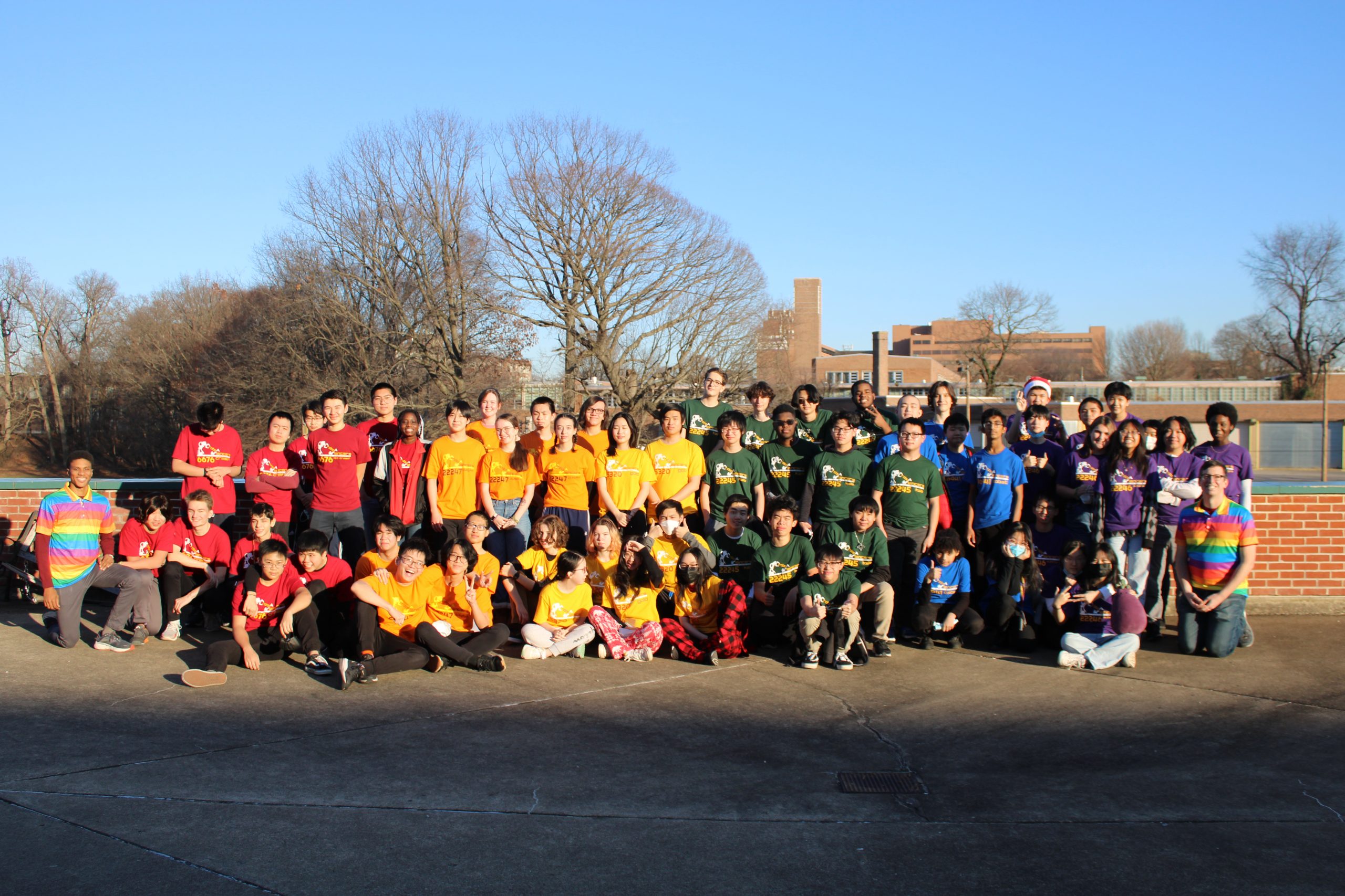 All 6 FTC Teams outside arranged like a rainbow in their team shirts.